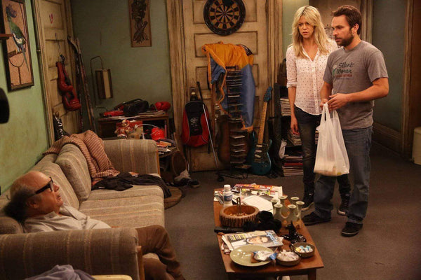 Sweet Dee, Charlie, and Frank starting at each other in Charlie's messy apartment from It's Always Sunny in Philadelphia