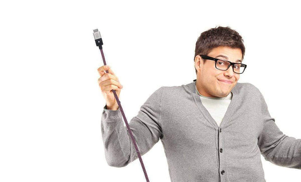 Man with glasses and cardigan holding and HDMI cable